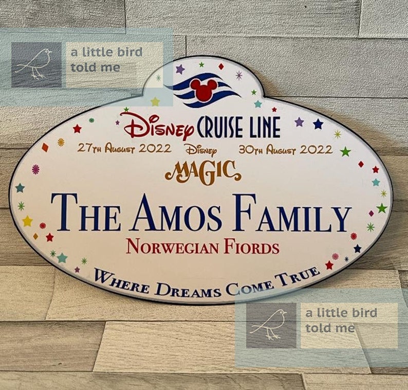 Puede incluir: Una etiqueta de nombre ovalada blanca de Disney Cruise Line con un borde azul y estrellas de colores. La etiqueta dice "Disney Cruise Line", "27 de agosto de 2022", "Disney Magic", "30 de agosto de 2022", "The Amos Family", "Norwegian Fjords" y "Where Dreams Come True".
