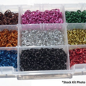 May include: A clear plastic storage box filled with small metal rings in various colors, including brown, pink, green, orange, silver, gold, blue, black, and red.  *Stock Kit Photo - See Size comparison photos*