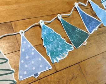 May include: A string of blue and green paper Christmas tree ornaments with white polka dots and a white string.