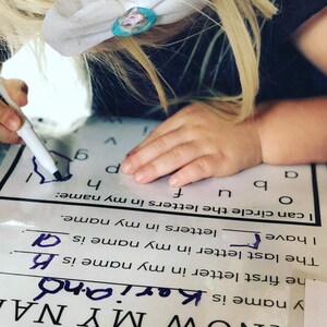 Puede incluir: Un ni&ntilde;o est&aacute; aprendiendo a escribir su nombre. La hoja de trabajo le pide que circule las letras de su nombre. El ni&ntilde;o ha circulado la letra K y est&aacute; escribiendo la letra A.