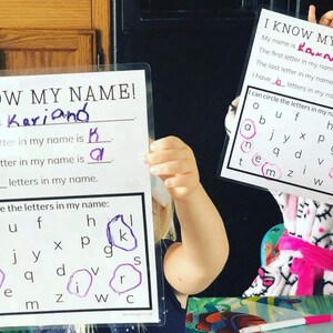 Puede incluir: Dos ni&ntilde;os est&aacute;n aprendiendo a deletrear sus nombres. Un ni&ntilde;o sostiene una tarjeta blanca con las palabras "I KNOW MY NAME!" y el texto "My name is Kariand" con las letras "K" y "d" rellenas. El otro ni&ntilde;o sostiene una tarjeta blanca con las palabras "I KNOW MY NAME!" y el texto "My name is Kakmen" con las letras "K" y "n" rellenas. Ambas tarjetas tienen una cuadr&iacute;cula de letras con las letras de sus nombres en c&iacute;rculo.