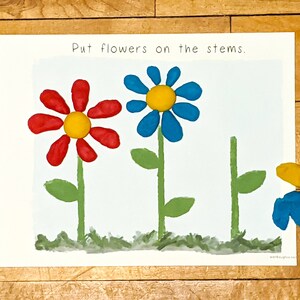 Puede incluir: Una hoja de actividad imprimible con el texto "Poner flores en los tallos". Se dibujan tres tallos de flores con hojas verdes. Una flor roja con un centro amarillo y una flor azul con un centro amarillo se colocan en los tallos. Se muestra una flor azul con un centro amarillo por separado.