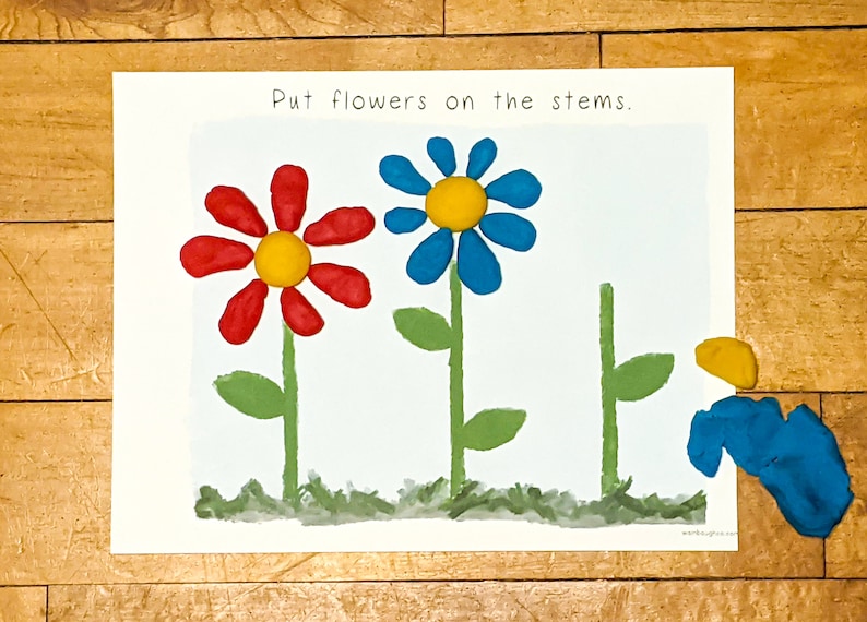 Puede incluir: Una hoja de actividad imprimible con el texto "Poner flores en los tallos". Se dibujan tres tallos de flores con hojas verdes. Una flor roja con un centro amarillo y una flor azul con un centro amarillo se colocan en los tallos. Se muestra una flor azul con un centro amarillo por separado.