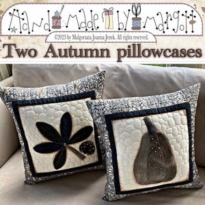 Könnte beinhalten: Zwei dekorative Kissenbezüge mit Herbstmotiven. Ein Kissenbezug zeigt ein schwarz-weißes Blattdesign, während der andere eine braune Kürbis mit einer strukturierten Oberfläche zeigt.