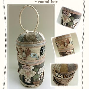 Könnte beinhalten: Eine dreistöckige runde Box mit einem Griff, hergestellt aus Stoffresten und mit einem Haus-Motiv verziert. Die Box ist 20,5 cm hoch und 10 cm im Durchmesser. Die Box ist mit Garnrollen und Nähnadeln gefüllt.