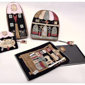 May include: A set of four felt house-shaped pouches with different designs. The pouches are black with red, pink, and brown accents. The pouches are decorated with stitching and fabric scraps. The pouches are labeled "Needles" and "Ideas".