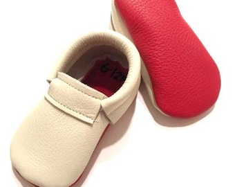 Mocasines de bebé hechos a mano de piel color marfil, suela roja