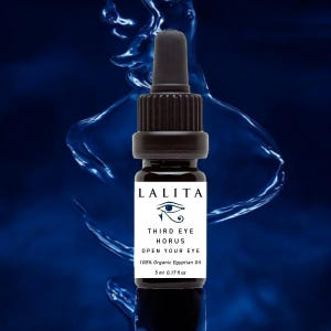 以下が含まれることがあります： 「LALITA」と「THIRD EYE HORUS OPEN YOUR EYE」のラベルが付いた、小さな黒いガラス瓶。ラベルには「100% Organic Egyptian Oil」と「5 ml 0.17 fl oz」も記載されています。背景はぼやけた青色のデザインです。