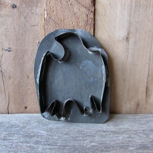 May include: Vintage metal cookie cutter shaped like a bird. The cutter is made of dark gray metal and has a rustic look.