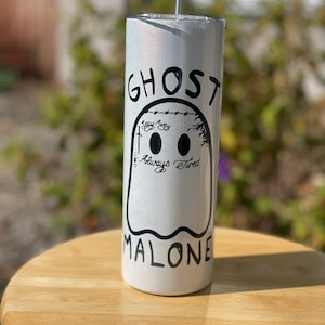 May include: White stainless steel tumbler with a black and white ghost design. The ghost has the text "Ghost" above it and "Malone" below it. The ghost also has the text "Stay Away" and "Always Tired" inside it.