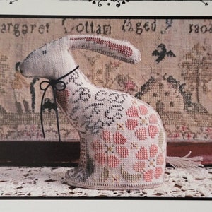 May include: A cross-stitch pattern for a sweet pea bunny. The pattern is called "Sweet Pea" and is designed by La-D-Da. The pattern is for counted thread.