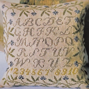 May include: A cross stitch sampler pattern featuring the alphabet, numbers 1-10, and a floral border. The title of the pattern is "Little Summer Sampler" and the designer is "La-D-Da designs for counted thread".