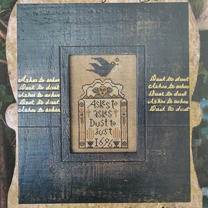 May include: A black raven sits atop a tombstone with the inscription "Ashes to Ashes, Dust to Dust, 1688". The image is framed in a dark wood frame with a distressed finish. The text "The Curse of the Raven" is at the top of the image. The text "Carriage House Samplings" is at the bottom of the image.