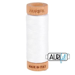 May include: A spool of white thread with a wooden bobbin. The bobbin is labeled "Aurifil" and "Made in Italy".