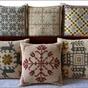 May include: Six embroidered pillow covers with various designs. The designs include geometric patterns, floral motifs, and a stylized animal. The pillow covers are in shades of green, brown, red, and blue.