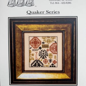 May include: A framed cross-stitch sampler with the word "LOVE" at the bottom. The sampler features geometric and floral patterns in red, brown, and black, with the year 2007 and the word "love" included. The frame is a dark wood color.