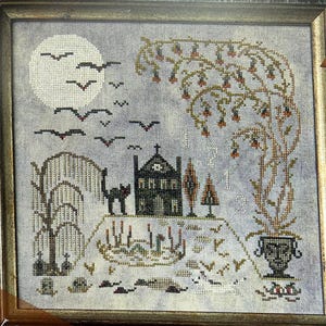 以下が含まれることがあります： ハロウィーンのシーンを描いたクロスステッチアート。満月、コウモリ、黒猫が特徴です。暗い家、木、装飾的な花瓶がデザインを完成させ、すべて木製のフレーム内にあります。