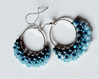 Round silver earrings with dark blue pearls and light blue crystal.