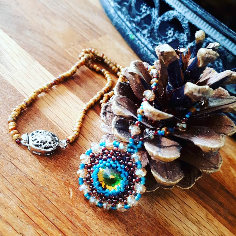 Beautiful charm necklace with folded rivoli in natural autumn colors.