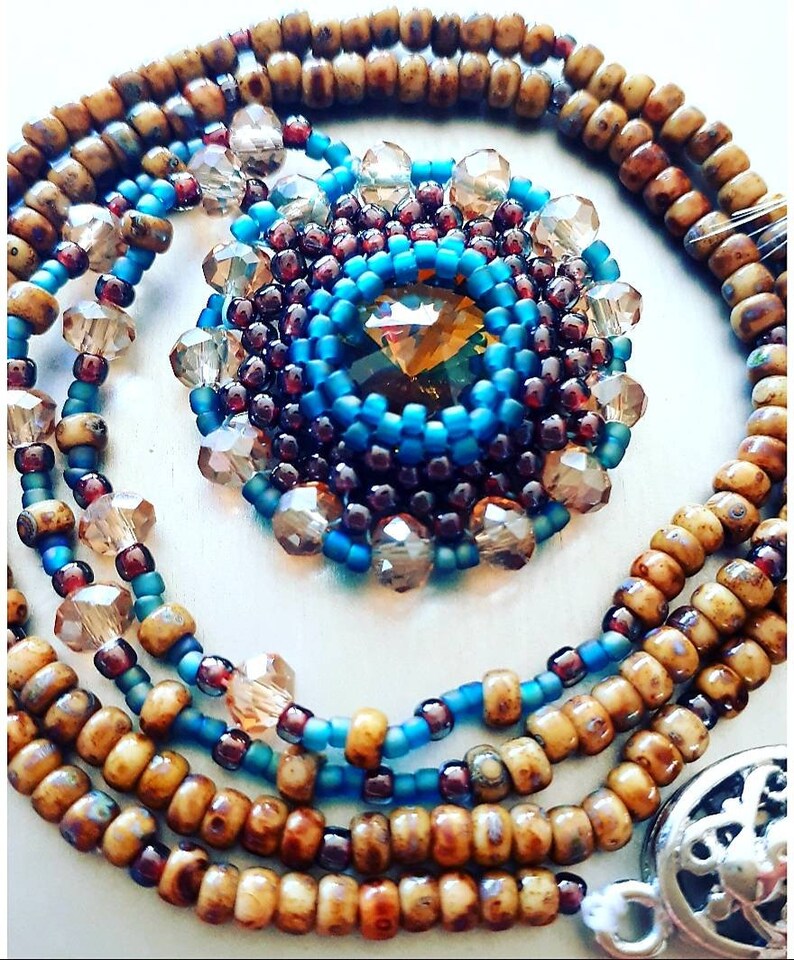 Beautiful charm necklace with folded rivoli in natural autumn colors.