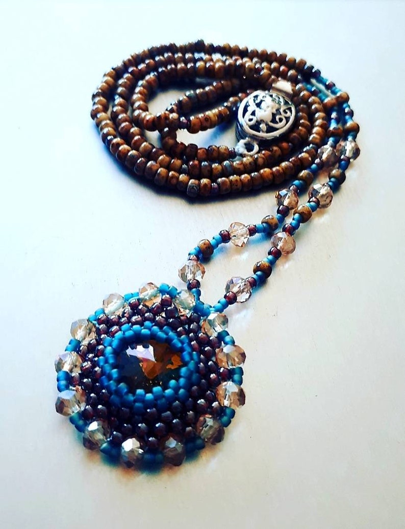 Beautiful charm necklace with folded rivoli in natural autumn colors.
