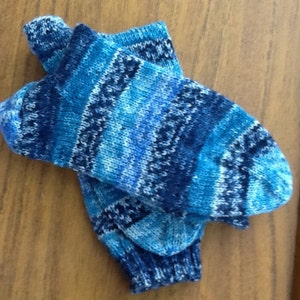 May include: A pair of blue and white patterned socks. The socks are knitted and have a geometric design.
