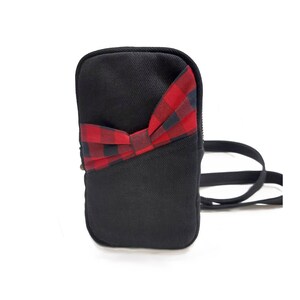 Bolso multifunción negro con bolsillo frontal con hebilla de cuadros. Bolsa de viaje para llevar cruzada al cuerpo, al hombro o a la cintura. Rockabilly.
