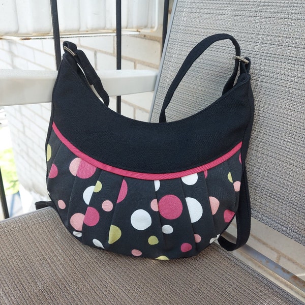 DERNIÈRE CHANCE! Petit sac à main noir à pois multicolores et biais rose par Loli. Sac bandoulière ajustable fermé par une fermeture éclair.