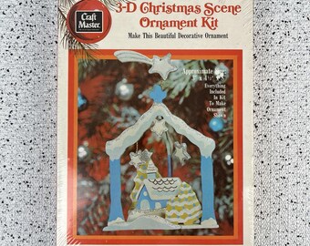 May include: A boxed Craft Master 3-D Christmas Scene Ornament Kit. The kit includes everything to make a decorative ornament. The finished ornament is approximately 3 x 4.5 inches and features a blue and white nativity scene with stars.