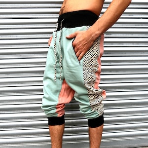 May include: A pair of light blue, pink, and black patterned pants with a drawstring waist. The pants have a geometric pattern on the side.
