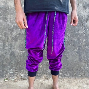 May include: Purple velvet pants with a black waistband and green and gold patterned side stripes.