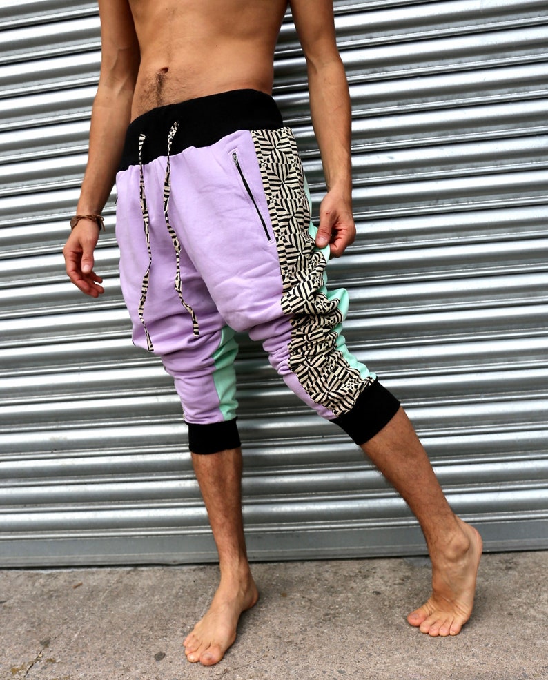 May include: Purple, green, and black patterned pants with a drawstring waist and zippered pockets.