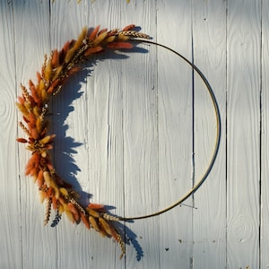 Natural Floral Metal Wreath with a gold finish. Adorned with dried golden flowers, dried pink and tan lagurus, wheat, and phalaris grass.