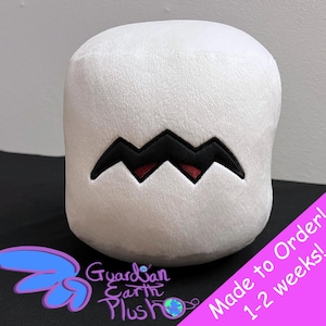May include: White plush toy shaped like a marshmallow with a black and red zig-zag pattern for a mouth. The toy is made to order and takes 1-2 weeks to ship. "Guardian Earth Plush" is written on the bottom of the image.