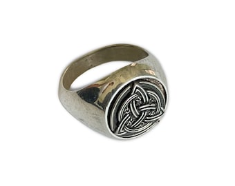 May include: A silver ring with a Celtic knot design. The ring is a classic style with a smooth band and a raised, detailed knot design.