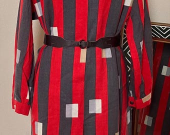 May include: A long-sleeved red and black striped dress with a white collar and a belt. The dress has a geometric pattern of squares in various colors.