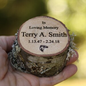 Pu&ograve; includere: Una targa commemorativa in legno con il testo "In Loving Memory Terry A. Smith 1.13.47 - 2.24.18" e una piccola silhouette di pesce.