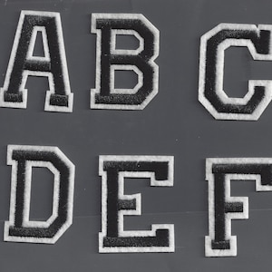 以下が含まれることがあります： 白い縁取りのある黒いフェルトの文字6つ。文字はA、B、C、D、E、Fです。