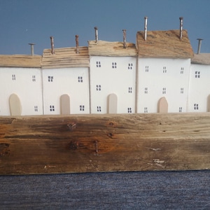 Unique miniature seaside houses handmade from driftwood and reclaimed wood for coastal decor, rustic art, recycled materials, eco-friendly.