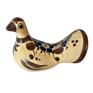 May include: A hand-painted ceramic bird figurine with brown, blue, and green floral designs on a cream background.