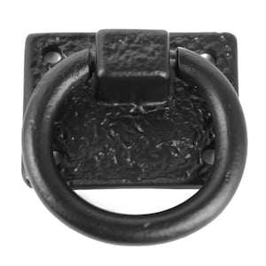 May include: Black cast iron ring pull handle with a square base. The handle has a textured finish.