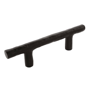 May include: A dark brown cabinet pull with a textured, organic design. The handle is a horizontal bar with two perpendicular T-shaped supports. The hardware is made of metal and is suitable for drawers or cabinets.