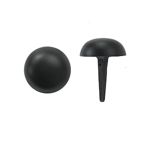 May include: Black metal nail head with a rounded top and a pointed bottom. The nail head is about 1 inch in diameter.