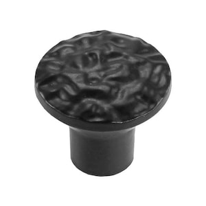 May include: Black cabinet knob with a textured, hammered finish. The knob has a round top and a cylindrical base.