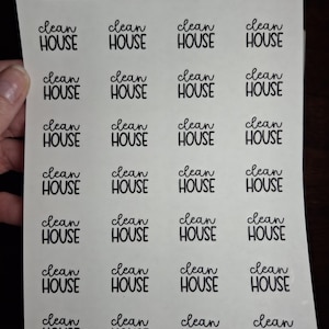 May include: A sheet of white stickers with the words "clean HOUSE" printed in a black, handwritten-style font. The stickers are arranged in rows and columns. The top of the sheet has the text "Sticky Impact" and "www.etsy.com/shop/stickyimpact".