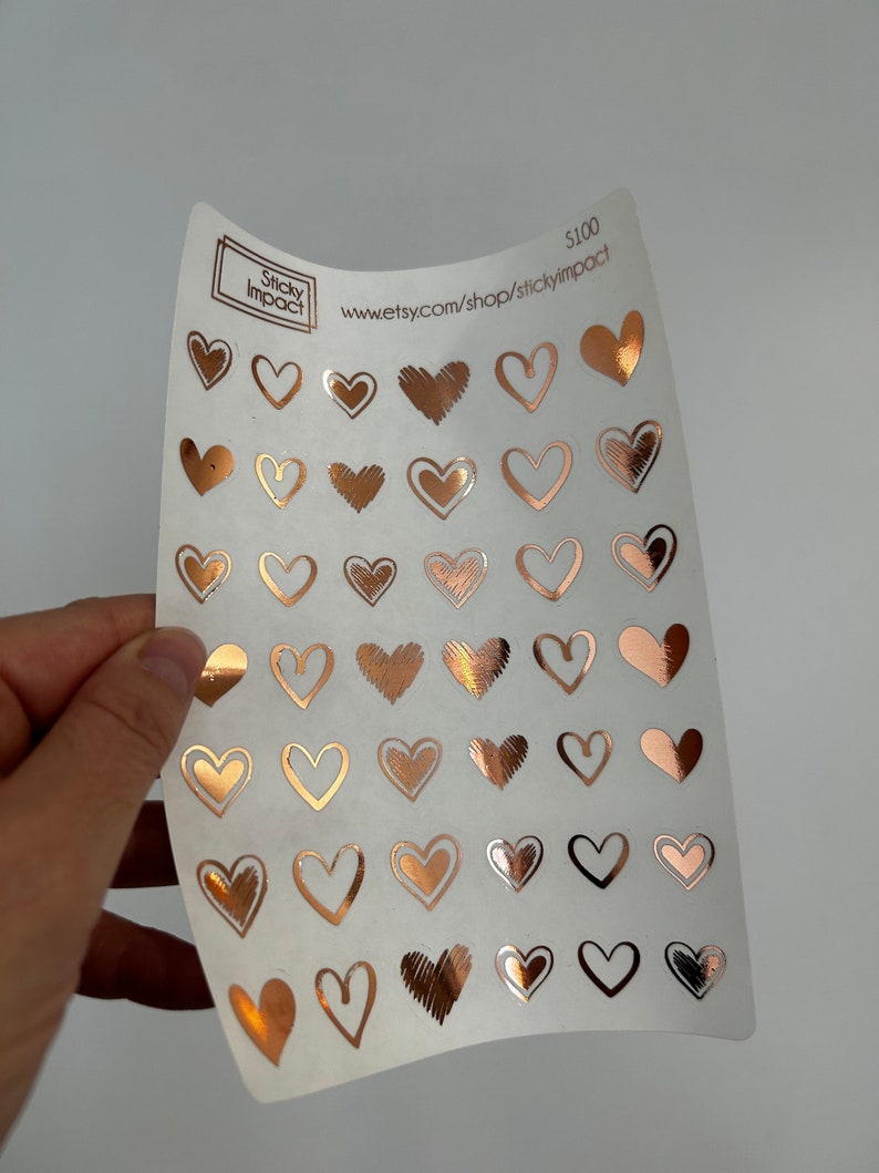 May include: A sheet of clear sticker paper with 40 rose gold heart stickers. The stickers are various sizes and styles. The sheet has the text "Sticky Impact" and "www.etsy.com/shop/stickyimpact" printed on it.  The price is listed as $100.