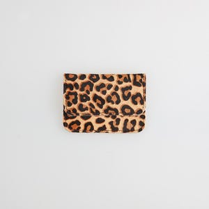 May include: A small, brown and black leopard print wallet.