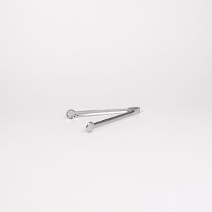 May include: Silver-toned metal tongs with rounded ends. The tongs are open and lying flat on a white surface.