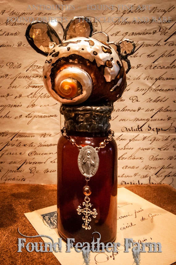 Handmade Glass Cross Bottle with an 1890's era Antique Mahogany Colored Glass Bottle Base with a Polished Sarmaticus Turbo Shell