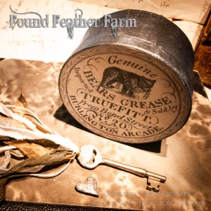 May include: A vintage round tin container with a black and white label that reads "Genuine Bears Grease & Sold by Truefitt, From Bond Street, Burlington Arcade."